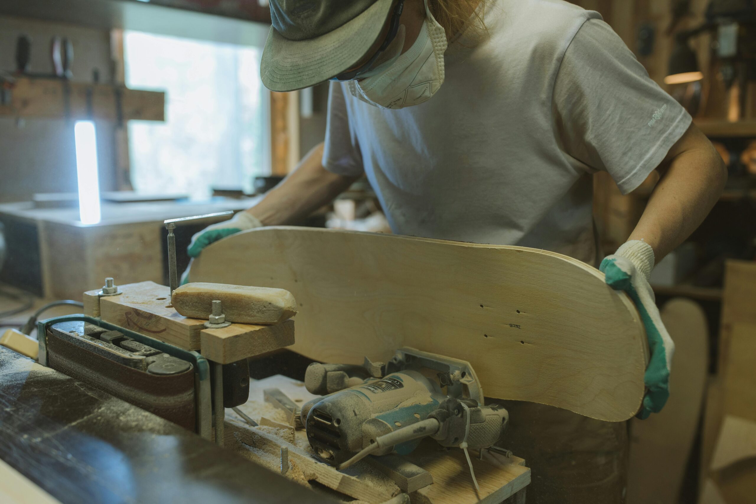 Experienced woodworker crafting a skateboard deck in a cozy workshop setting.